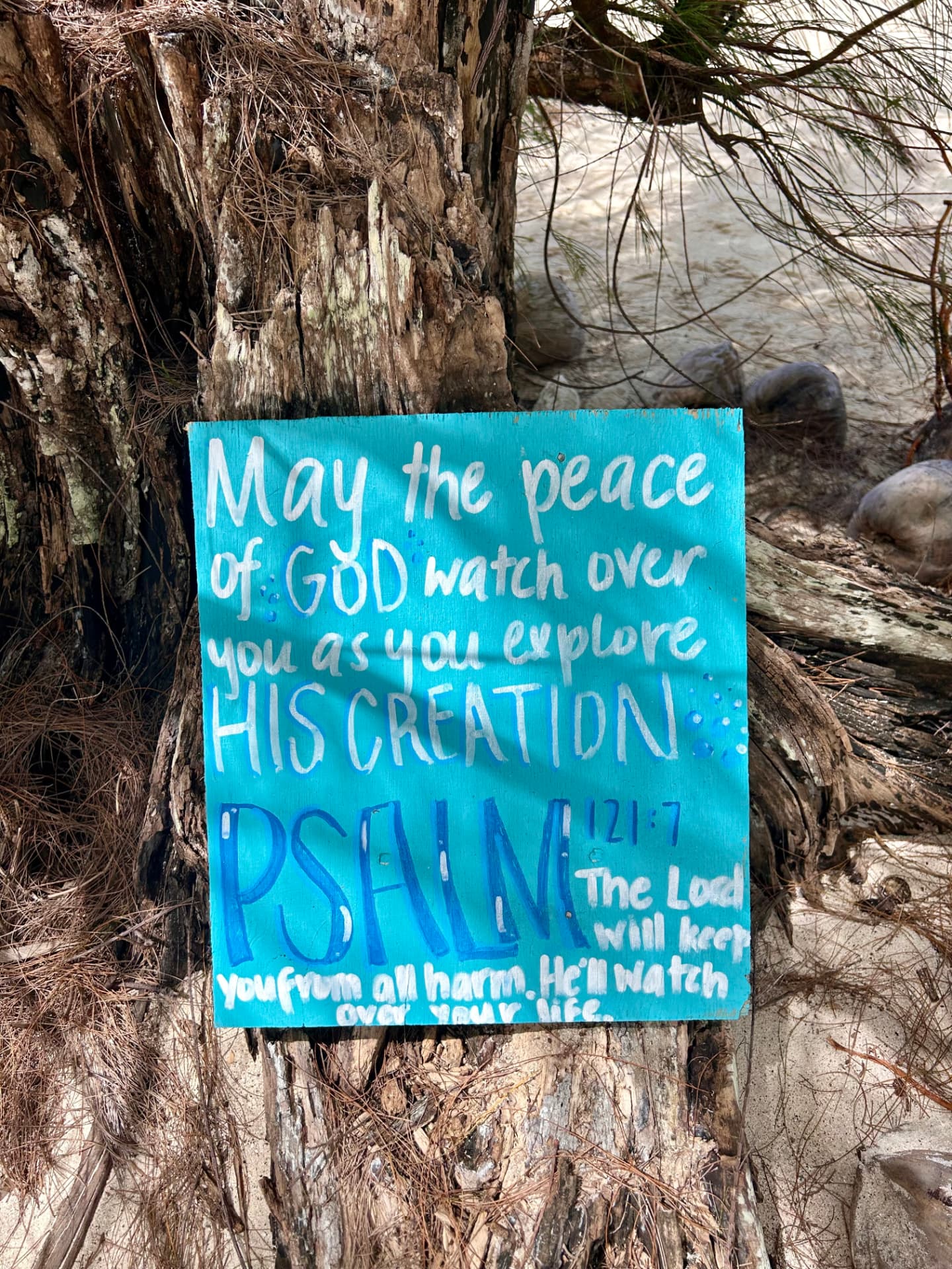 Hand-painted Psalm 121:7 sign at the Sea Pace beach meeting point