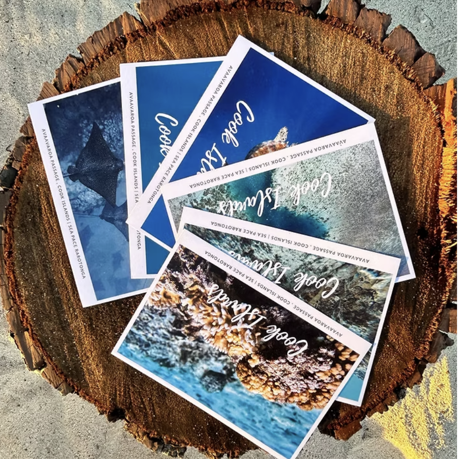 Sea Pace Cook Islands postcards laid out on a driftwood slab